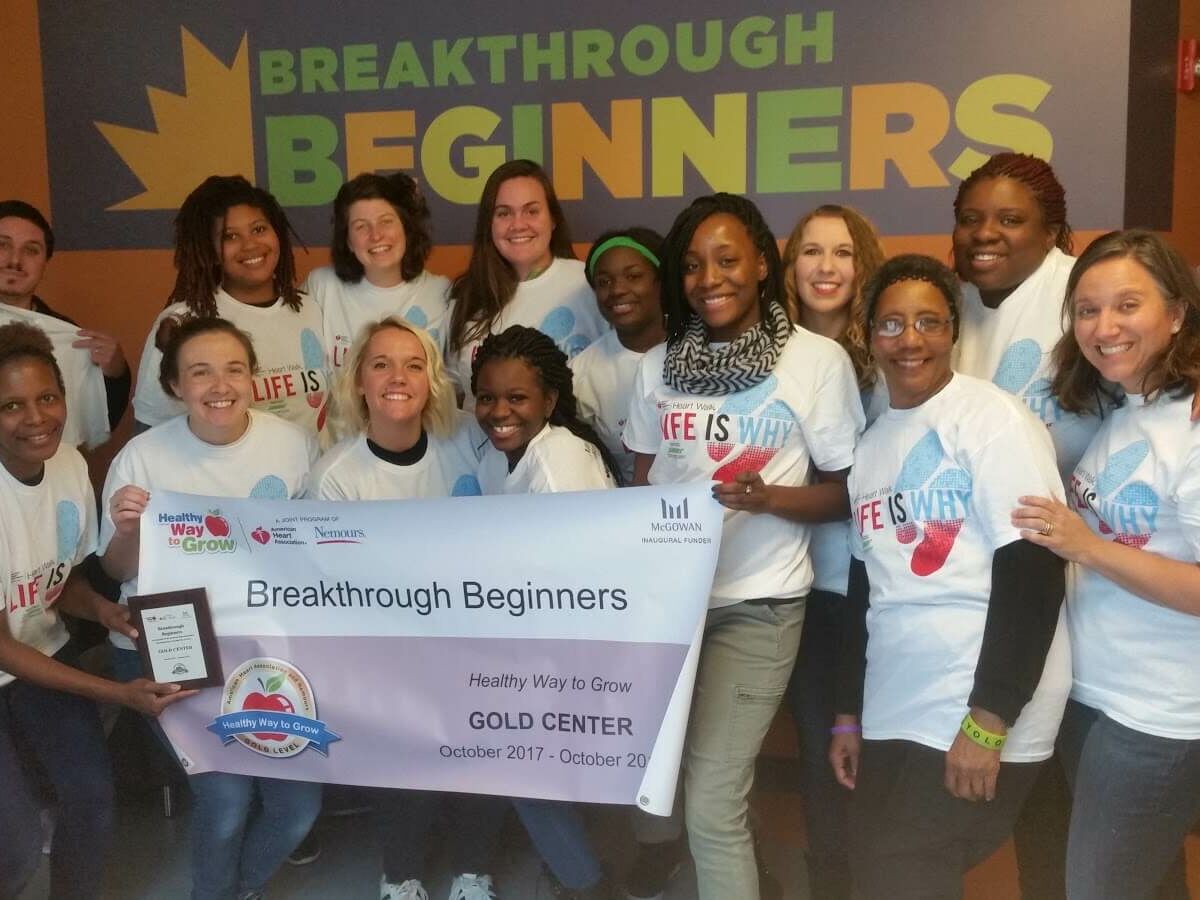 group of teachers posing with Gold certification banner for Breakthrough Beginners preschool