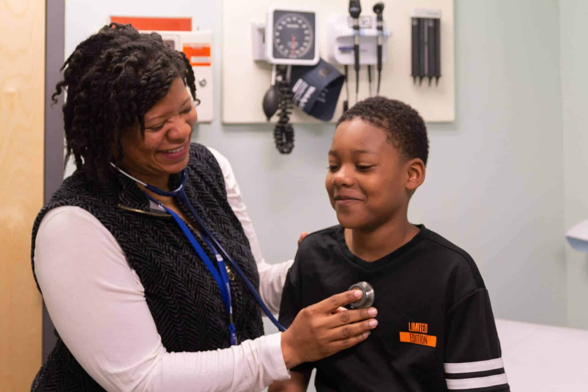 Doctor listening to boy's breathing with stethoscope