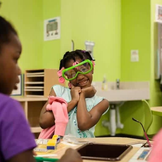 after school program student girl wearing goggles and smiling