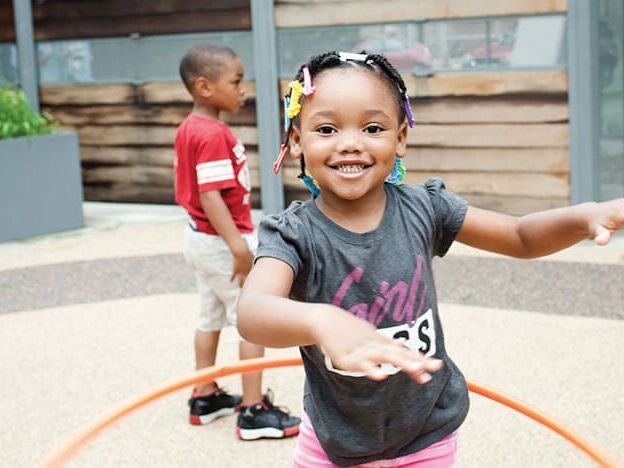 girl hula hooping during recess at Breakthrough Beginners preschool