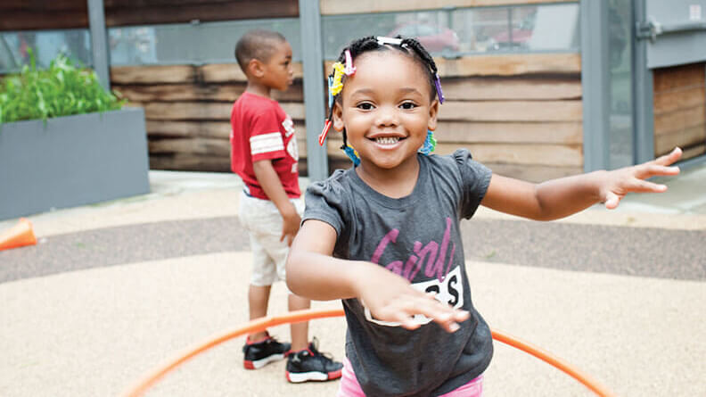 girl hula hooping during recess at Breakthrough Beginners preschool