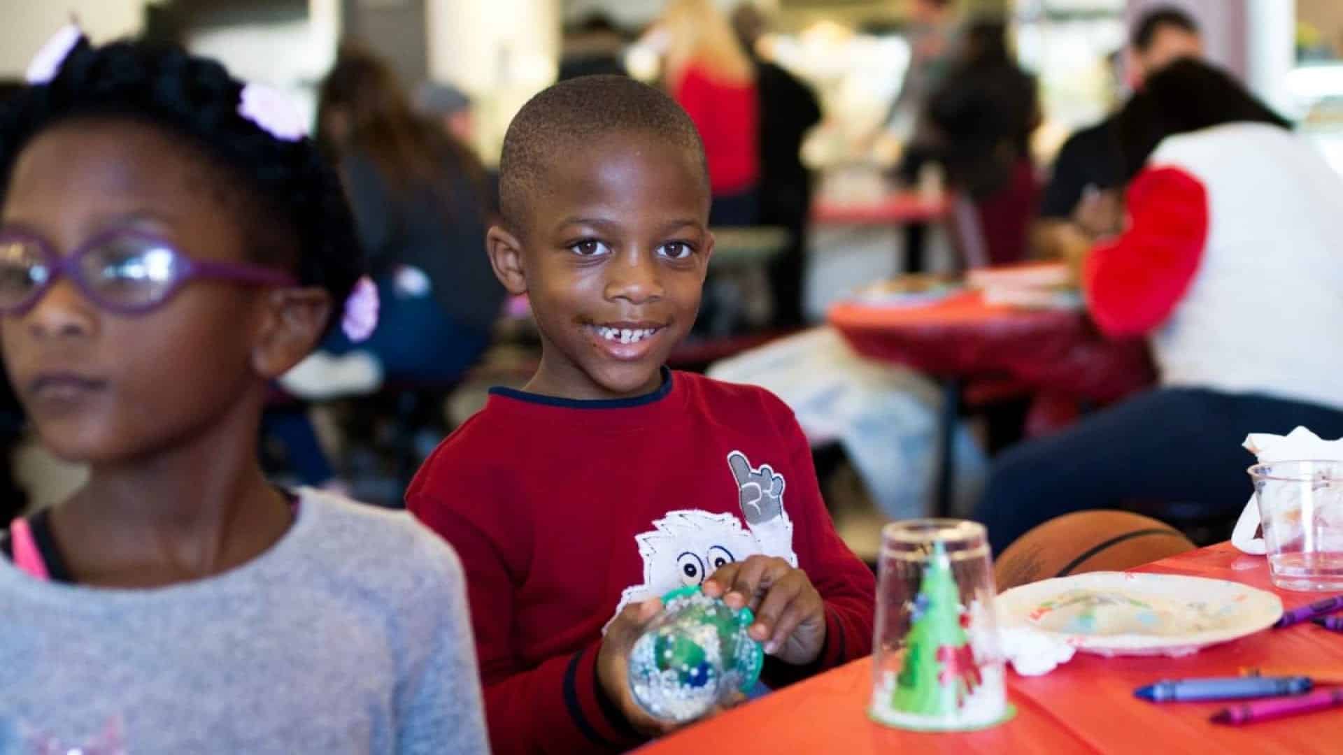 Boy making crafts at the Breakthrough Christmas Store